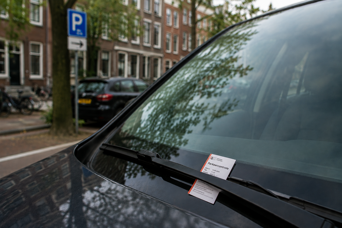 Parkeerbon van een parkeercontrole achter de ruitenwisser van een auto