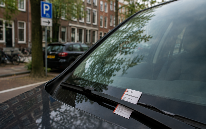 Parkeerbon van een parkeercontrole achter de ruitenwisser van een auto